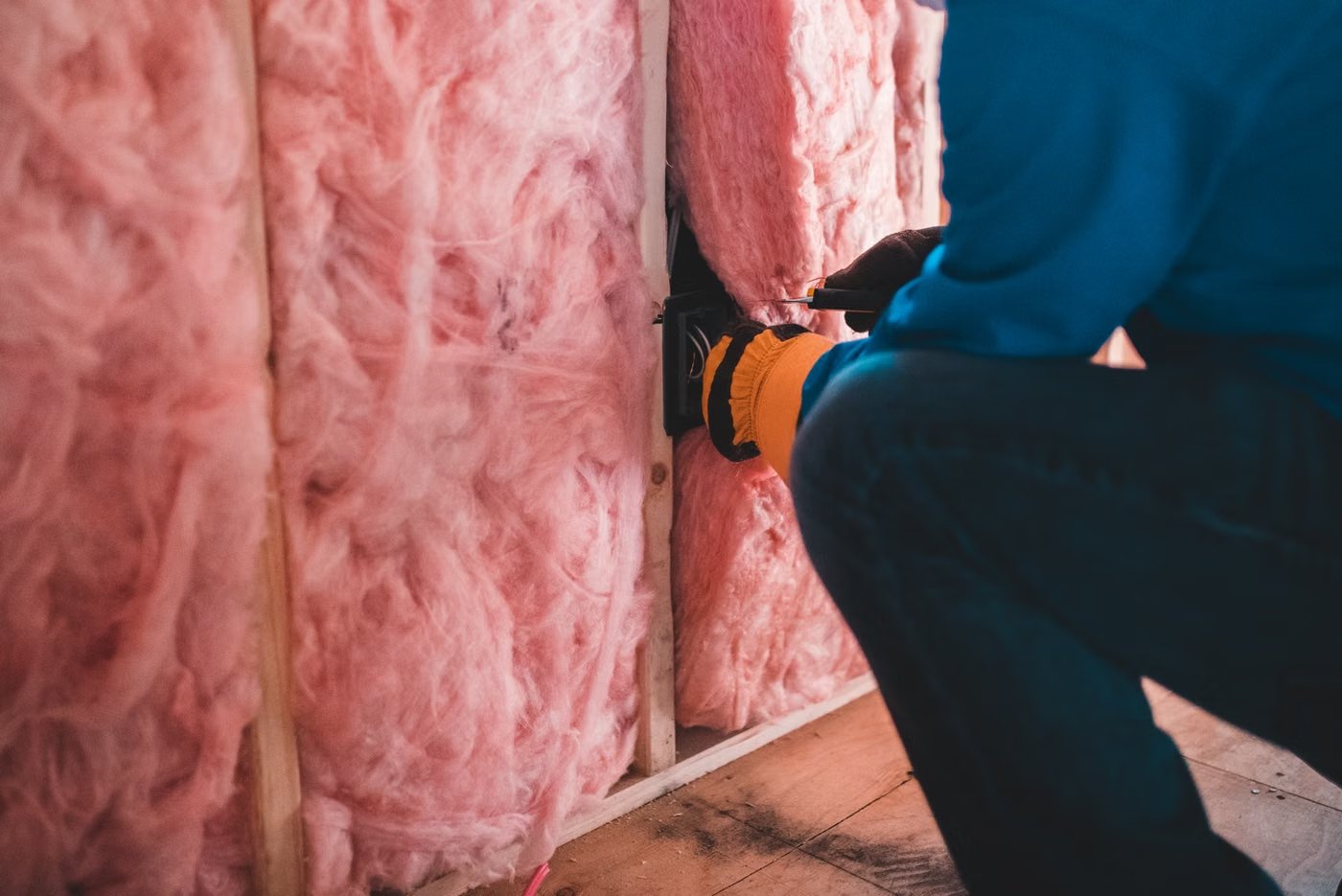 Handwerker bringt Dämmung in einem Dachboden an
