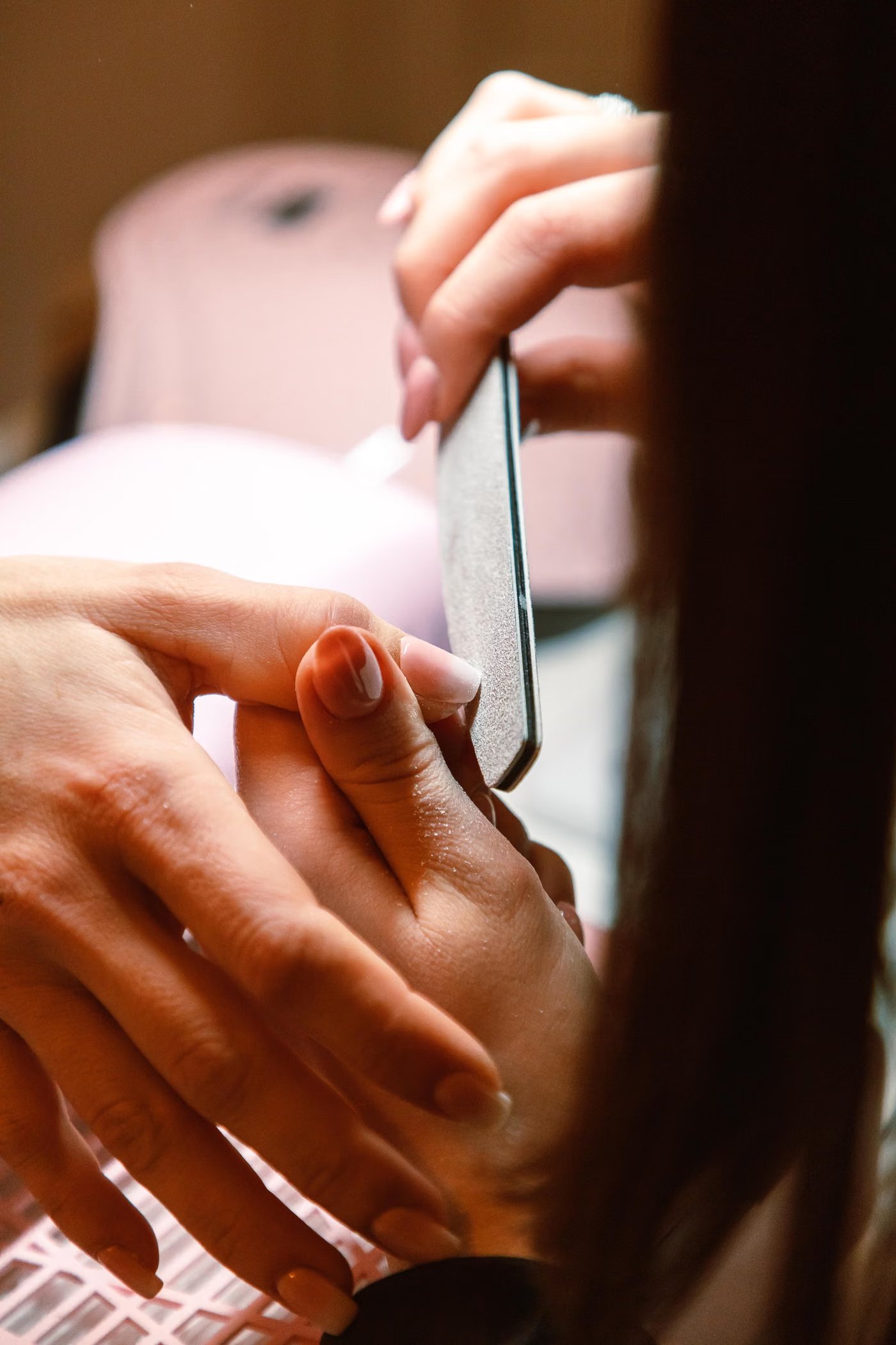 Nagelstylistin lackiert die Nägel einer Kundin